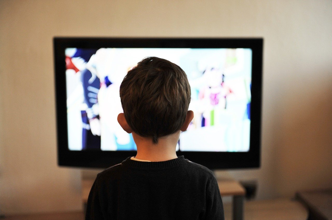 Seorang anak menonton televisi atau TV dan tidak sadar dengan lingkungannya.