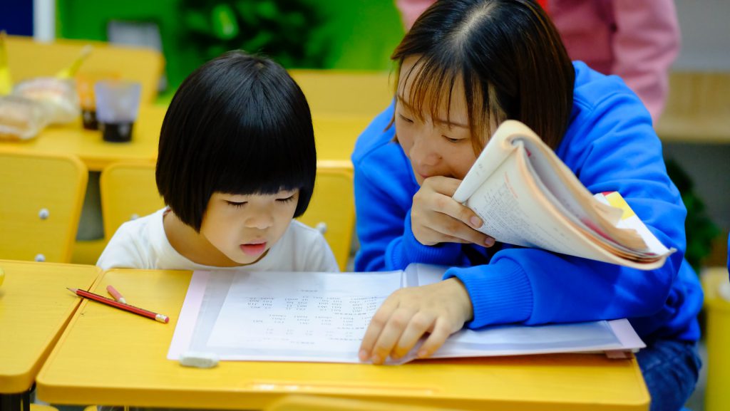 a mother helping her child to do homework